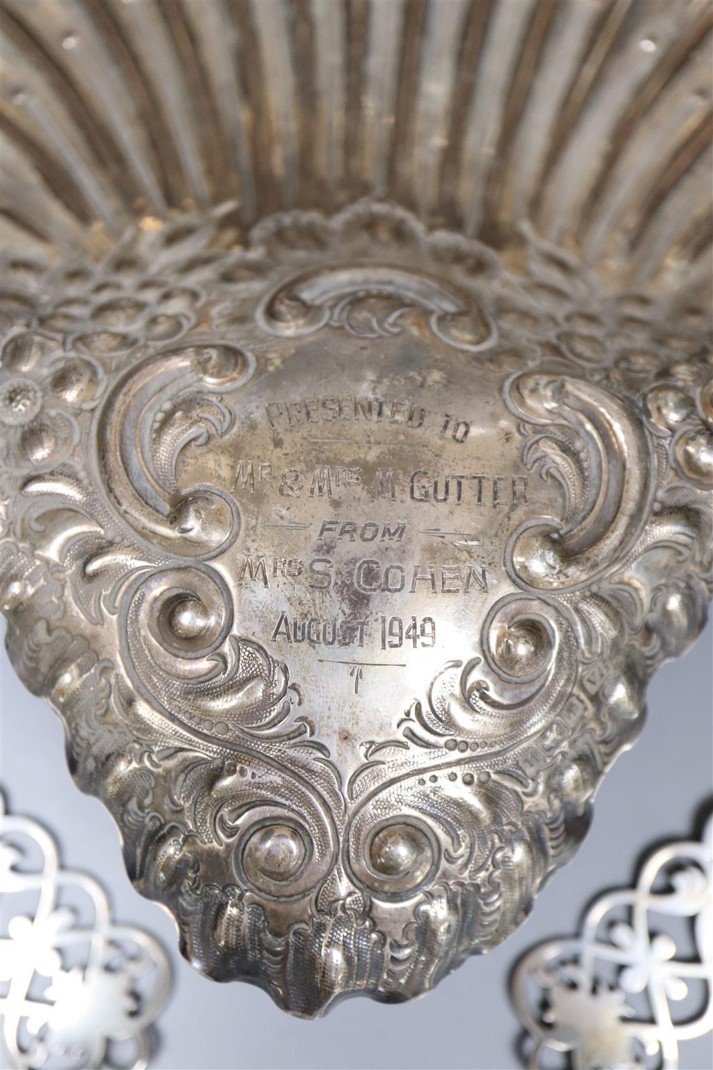 An Edwardian silver embossed and pierced scallop shaped dish, 28.3cm, Sheffield, 1905 and a pair of pierced silver spoons,12.5oz.